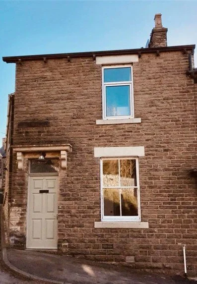 Image of the house including the front door and two windows.