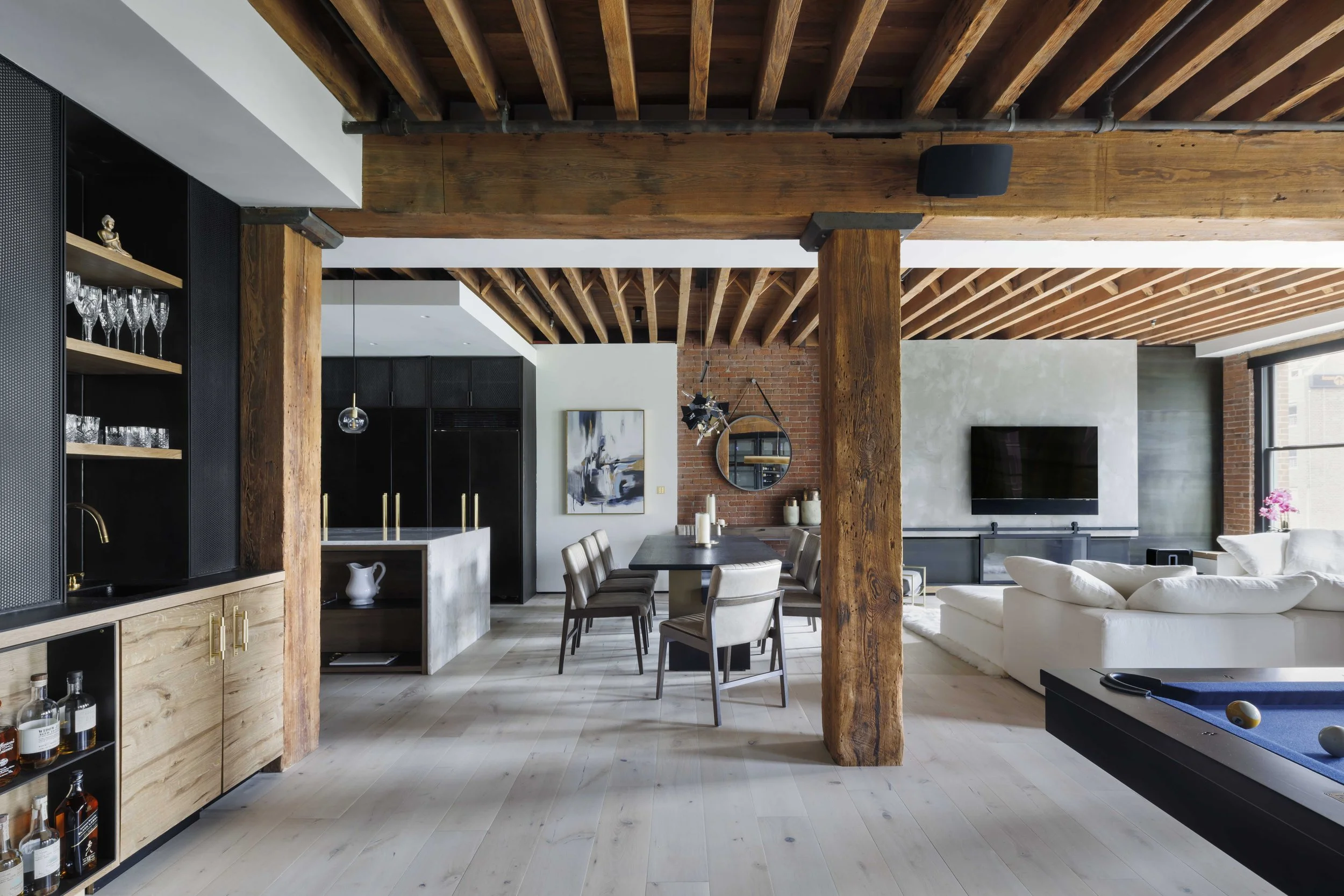  view of living area that consists of kitchen island, dining table, and white couch area with tv 
