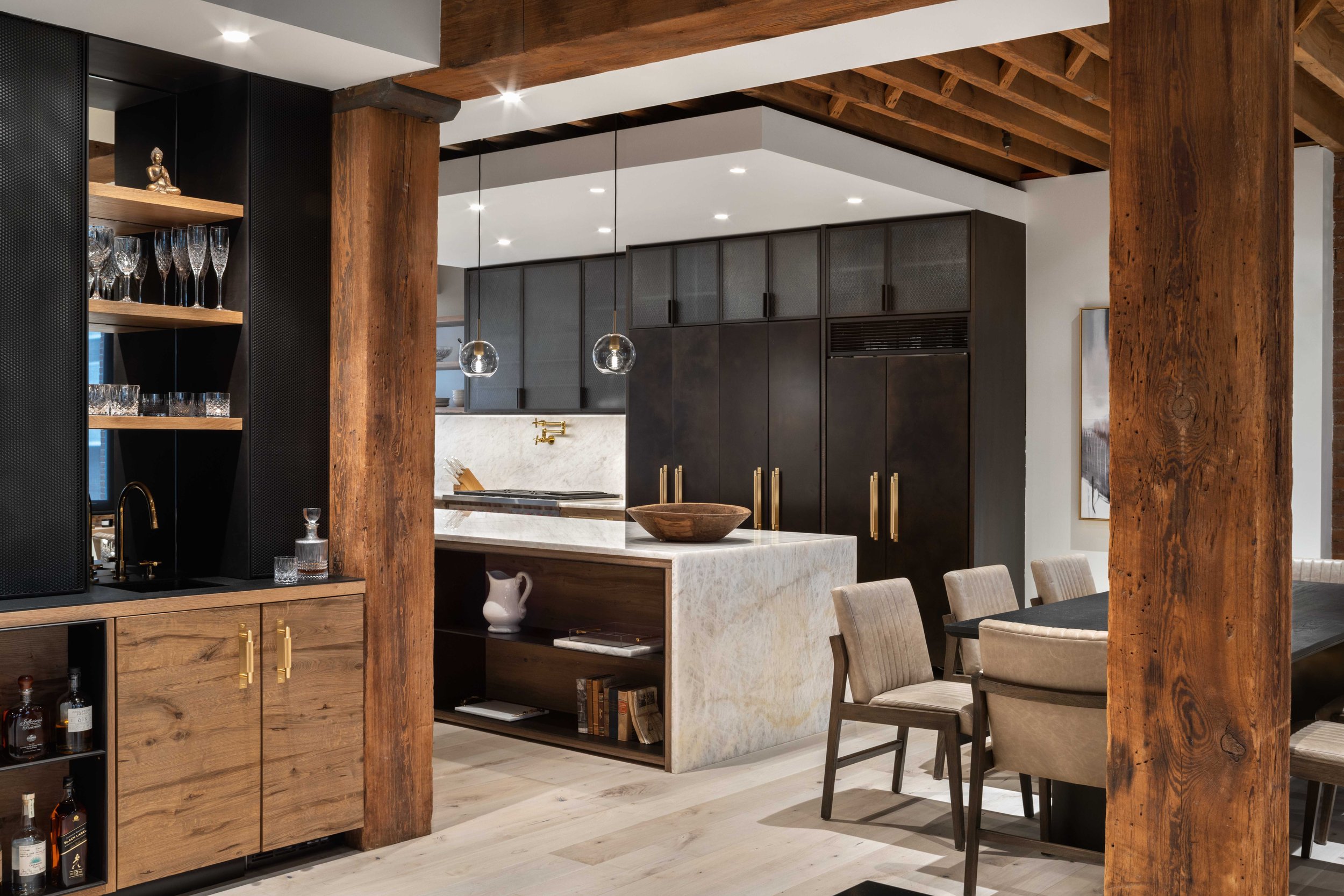  view of kitchen from living area with warm wooden accents and white marble countertops and backsplashes 