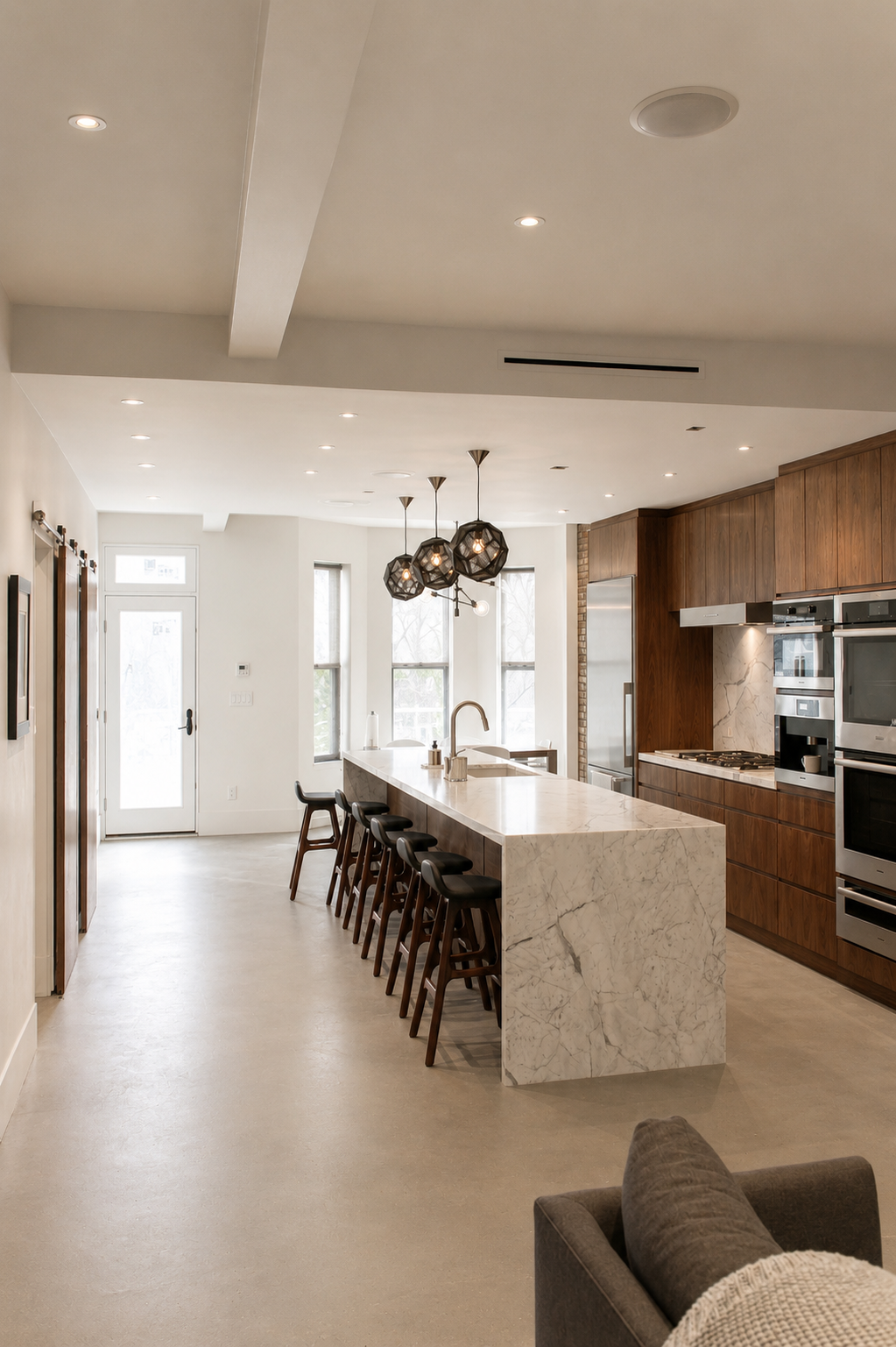  Sleek modern kitchen with marble countertop  bar, natural lighting, and cool tones 