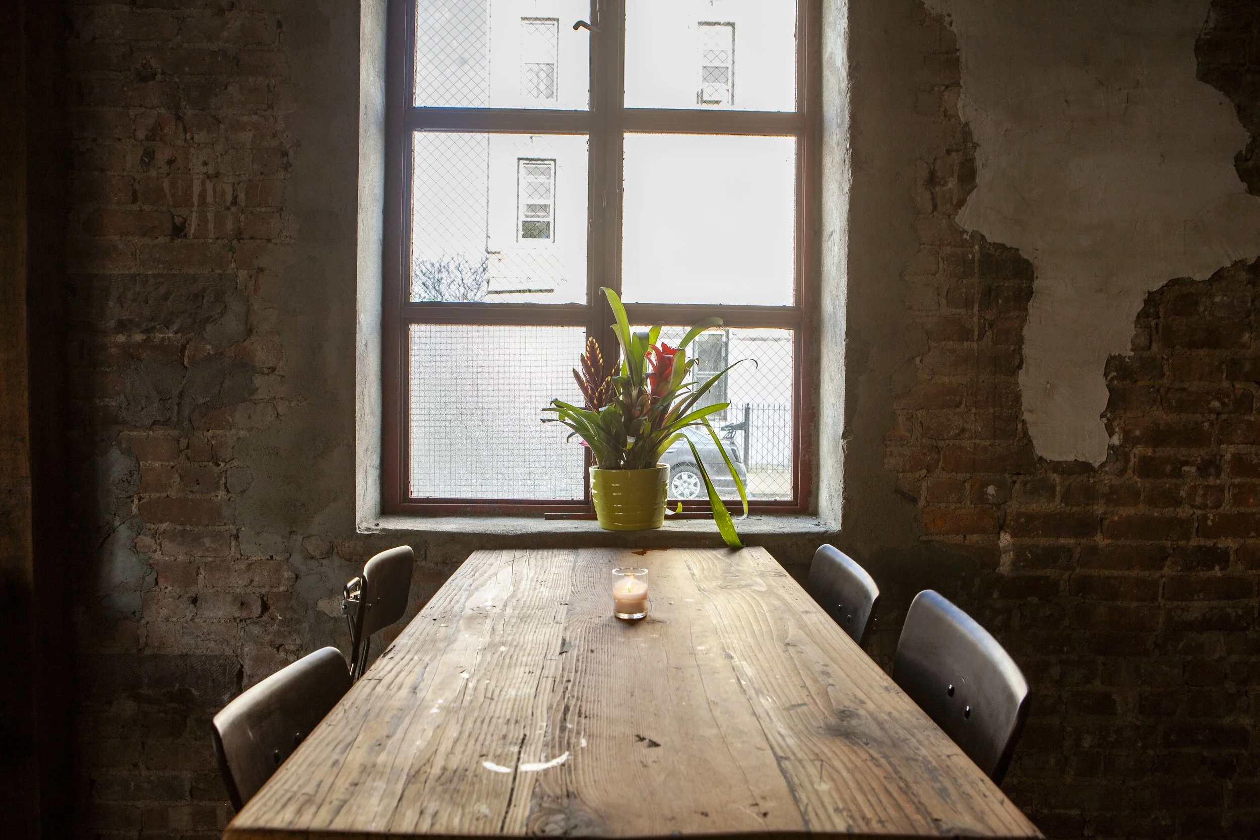  wooden table aligned with frosted window with delicate red toned table setting 