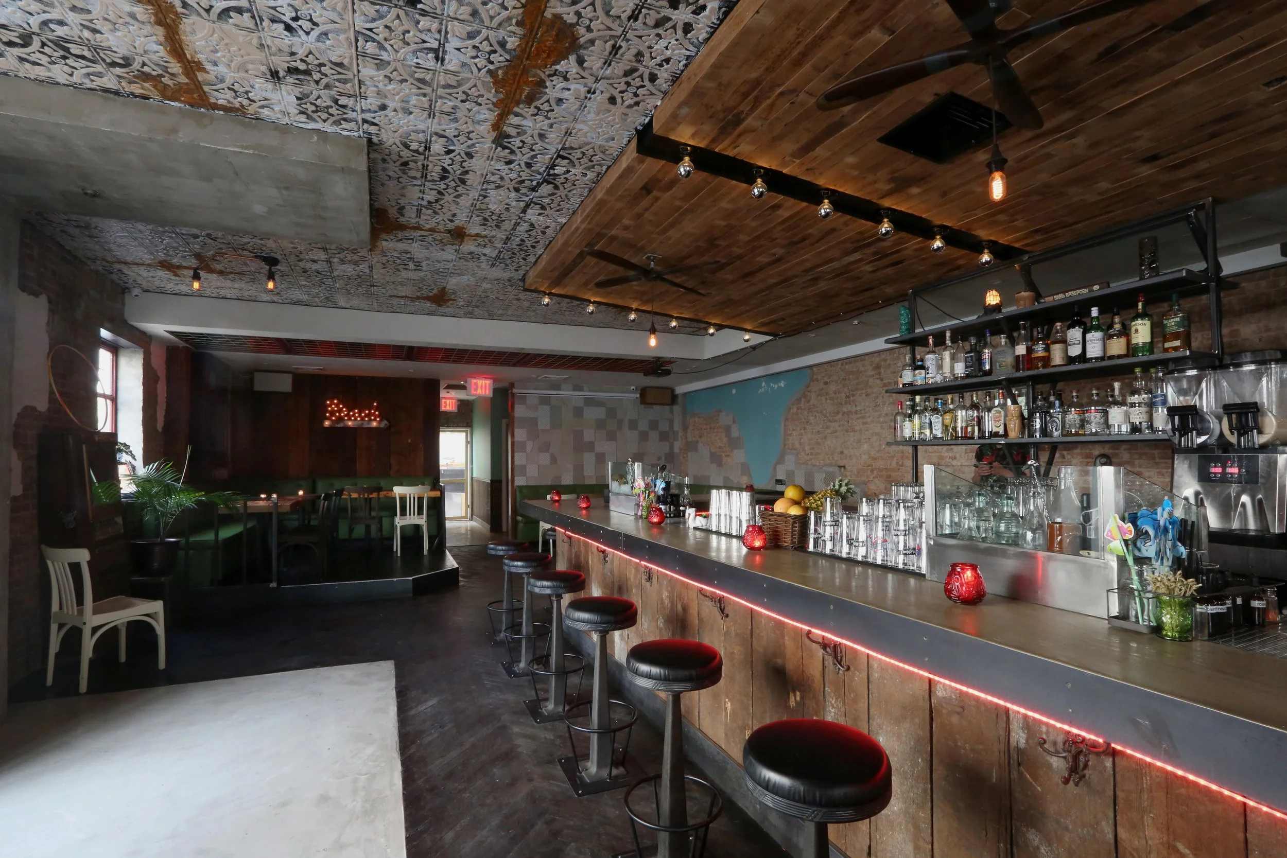  rustic bar view of counter with leather barstools and tarnished accents to neighboring walls 
