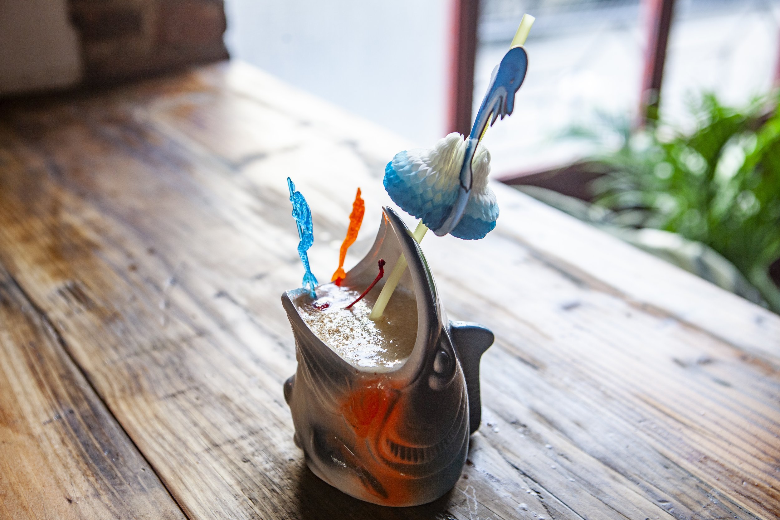  shark cup drink with red accent shown on wooden table 