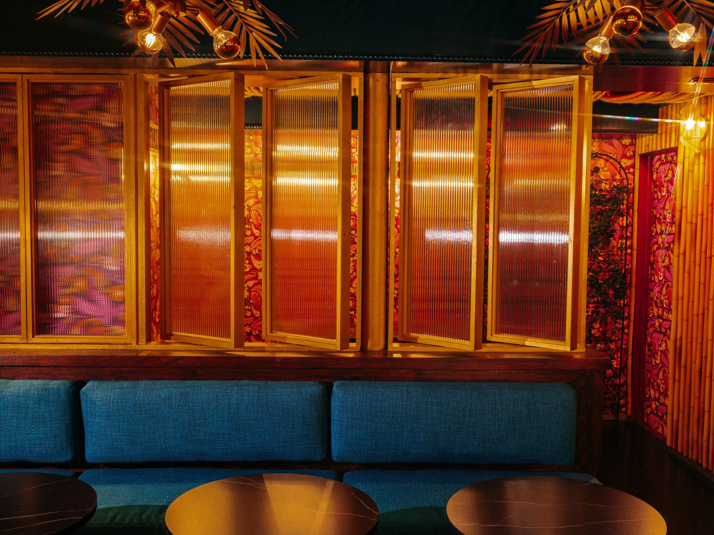  blue couches with wooden-framed accent windows that appear to have a sunset behind them 