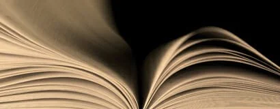 Close-up of an open book with pages curved upward.