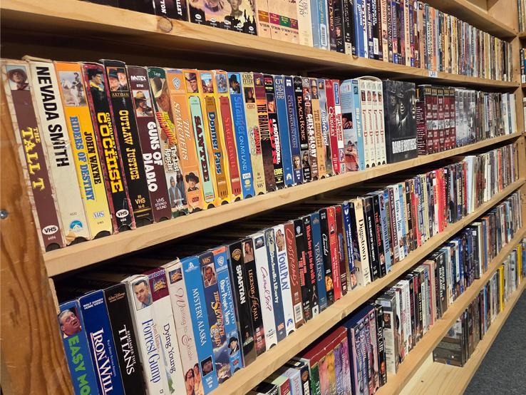 A large shelf displaying multiple rows of VHS movies
