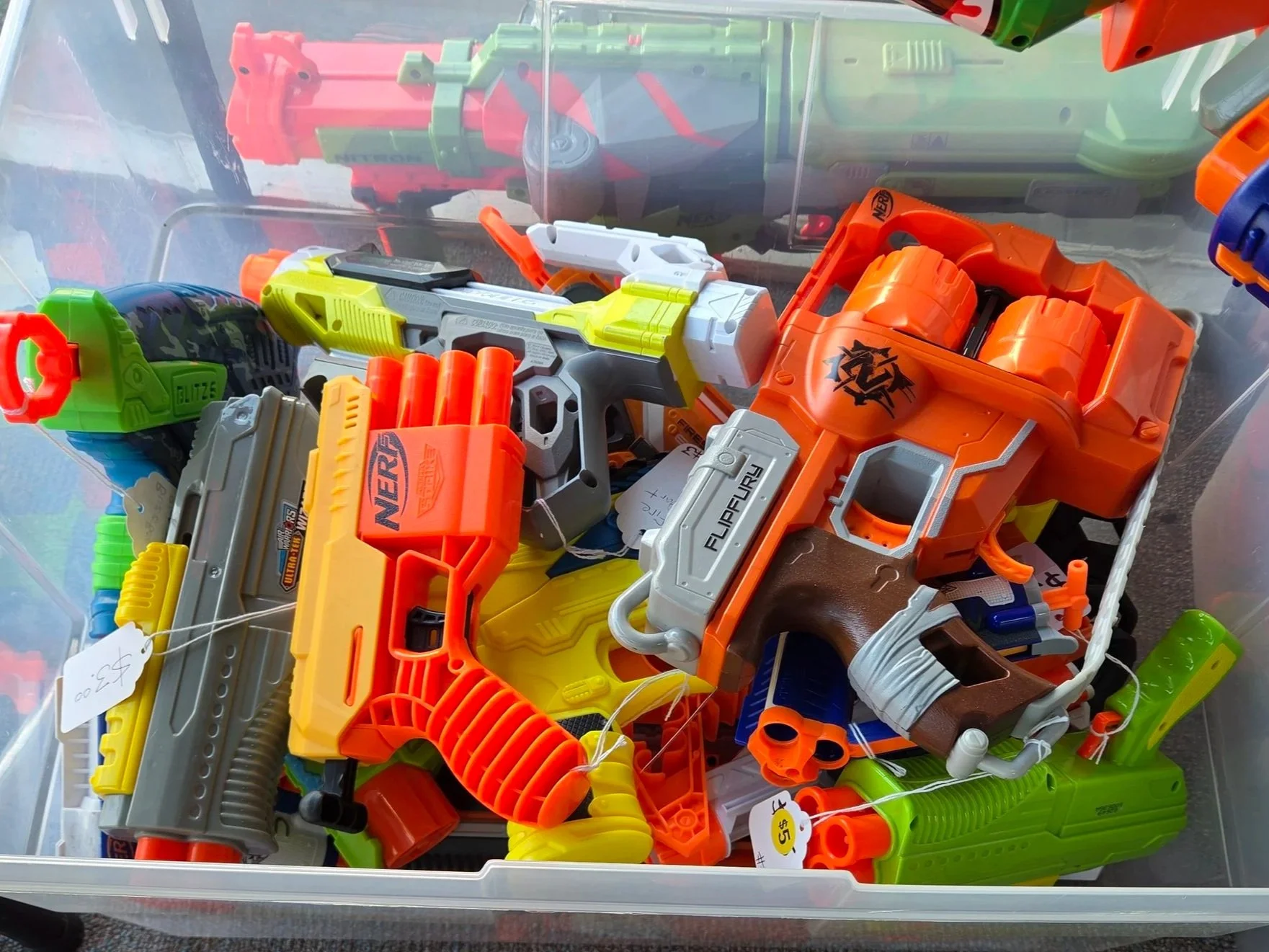 A bin filled with small colorful Nerf guns