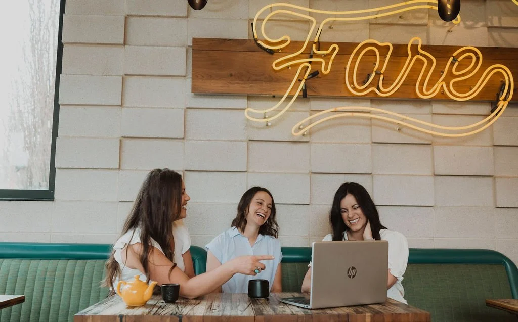 The Collective for Designers co founders Erin Hildmann and Keri Hinterreiter laughing during a business coaching session with interior designer Lauren Winters