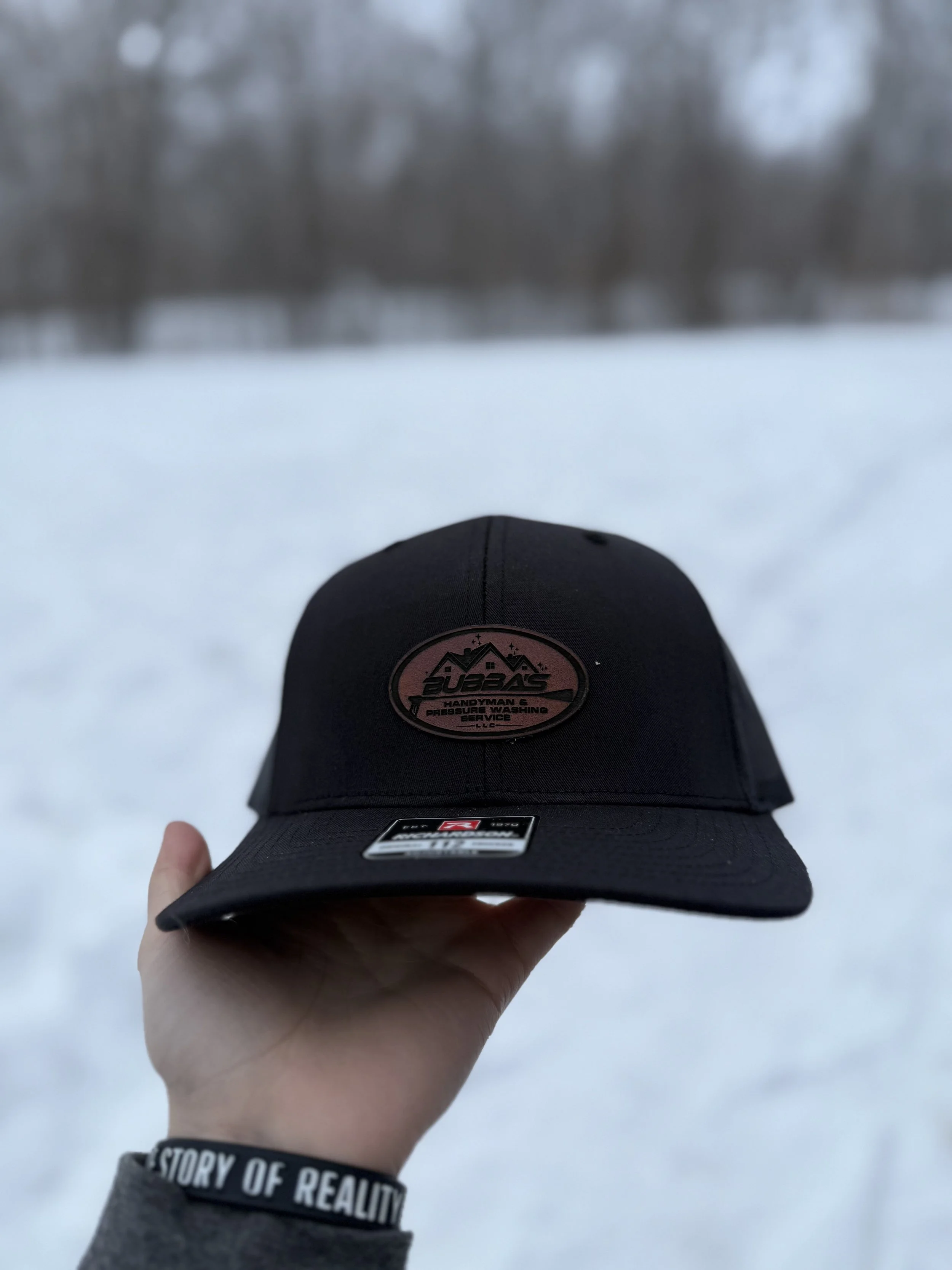 Black Richardson ball cap with rustic brown, laser engraved patch of custom business logo. 