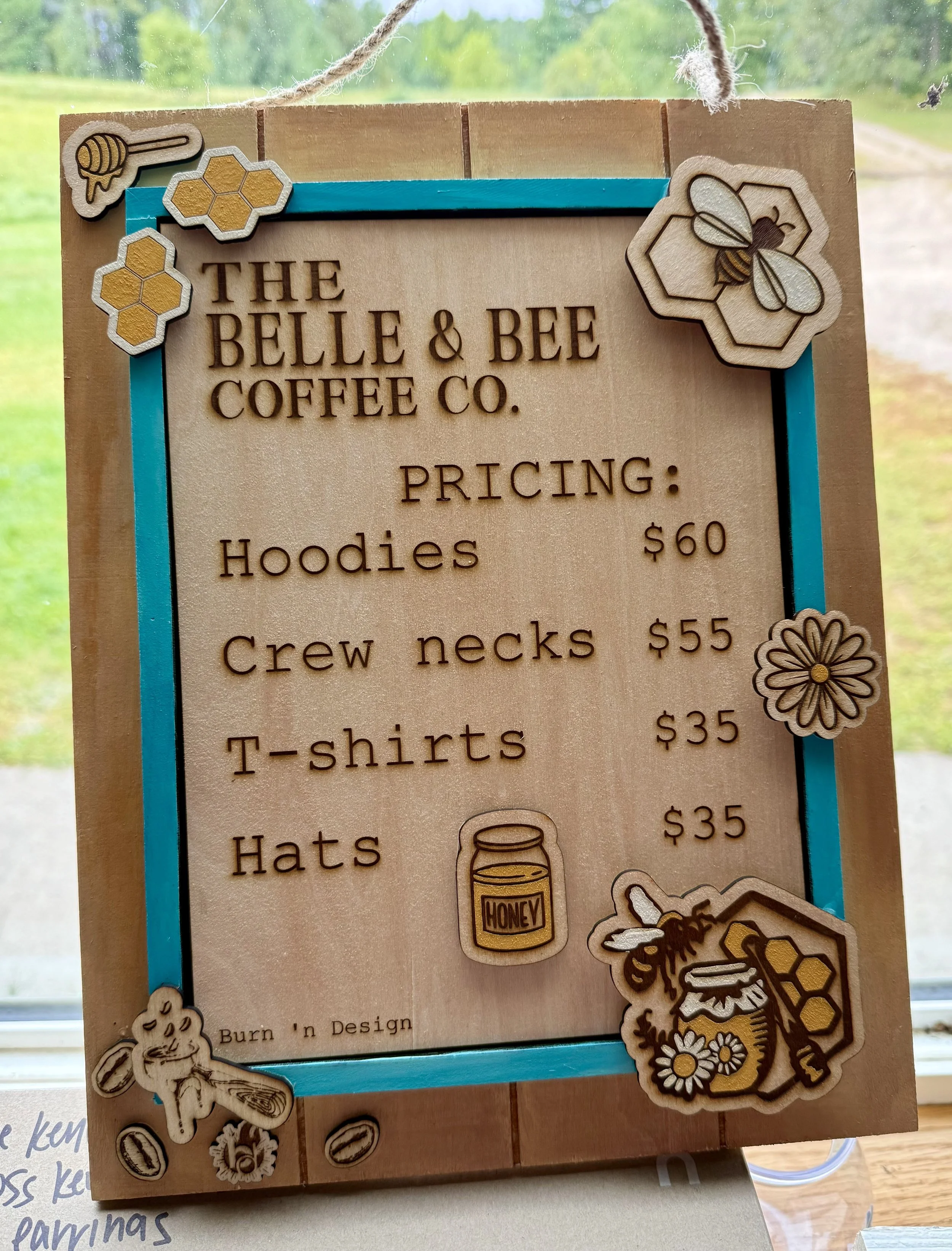 Hand-painted, engraved, and cut-out sign with custom pricing and additional details. Made for merchandise for a coffee shop. 
