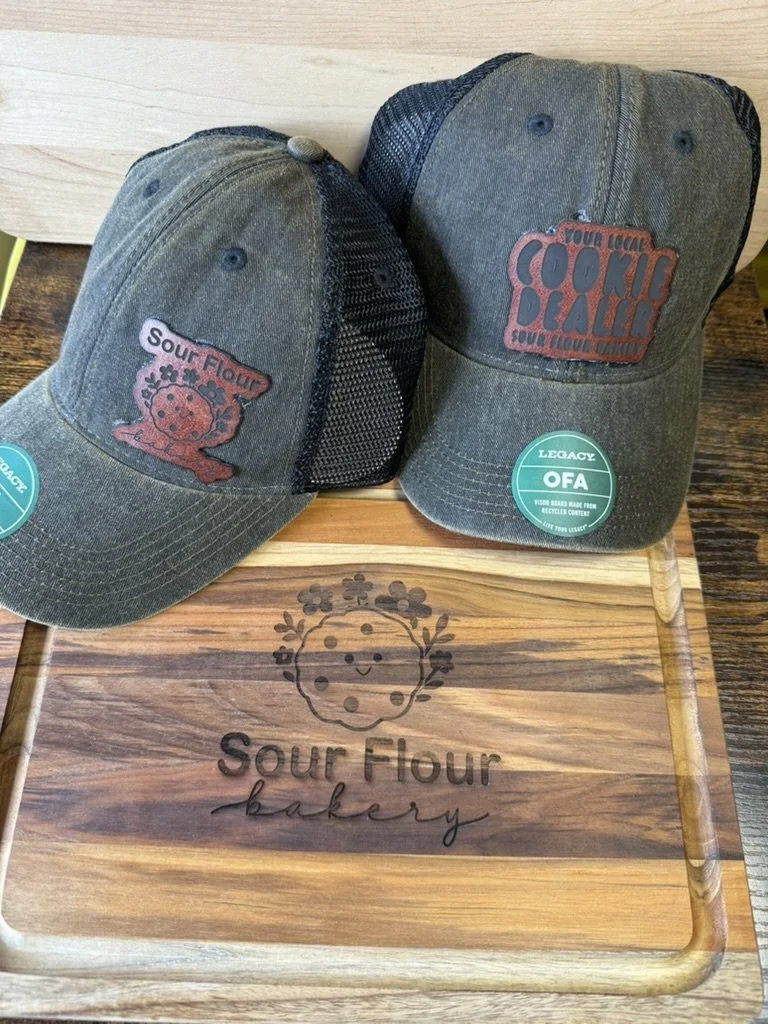 hats and cutting boards with logos for Sour Flour Bakery