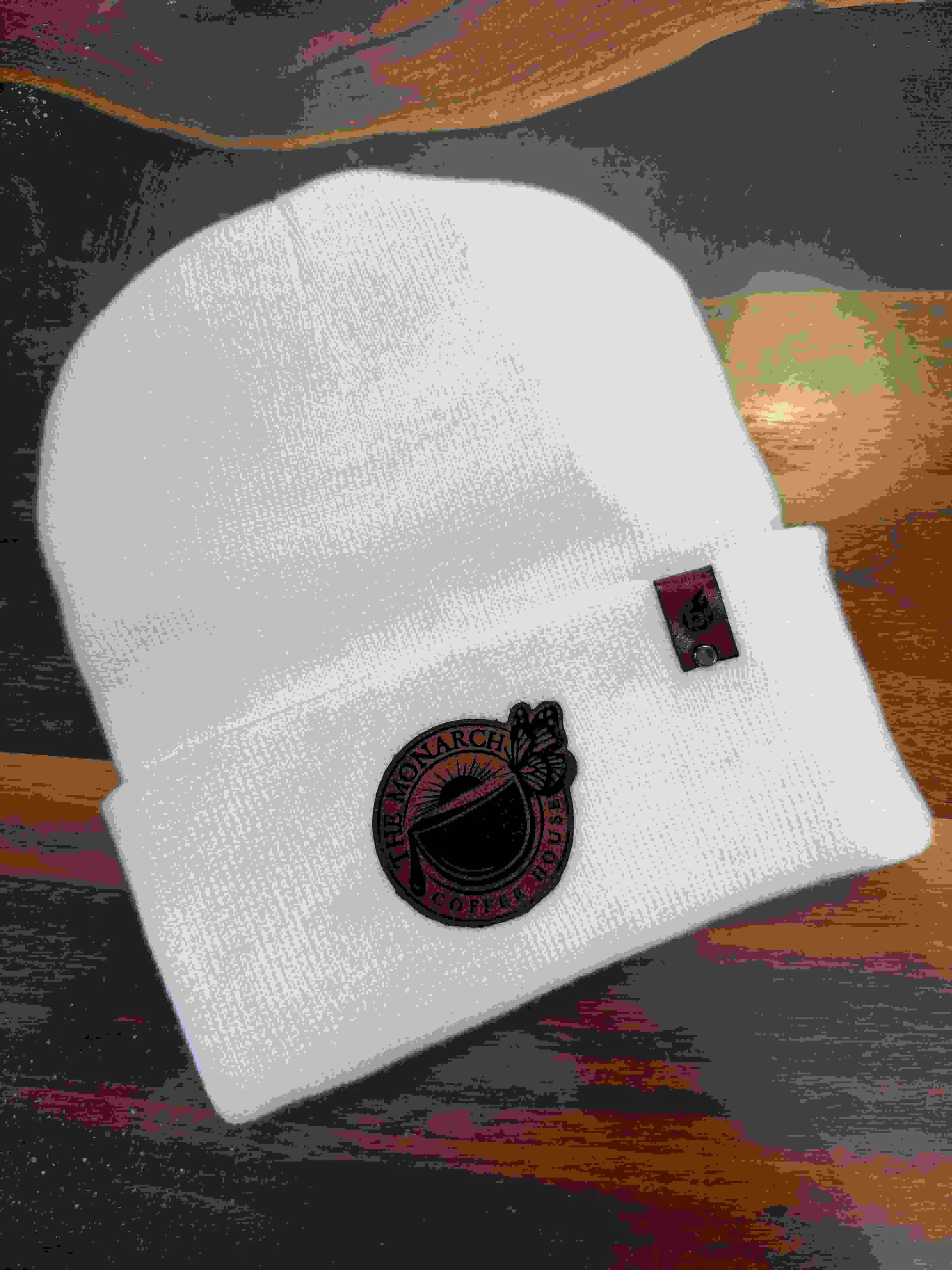 White beanie with a rustic brown, laser engraved business logo. 