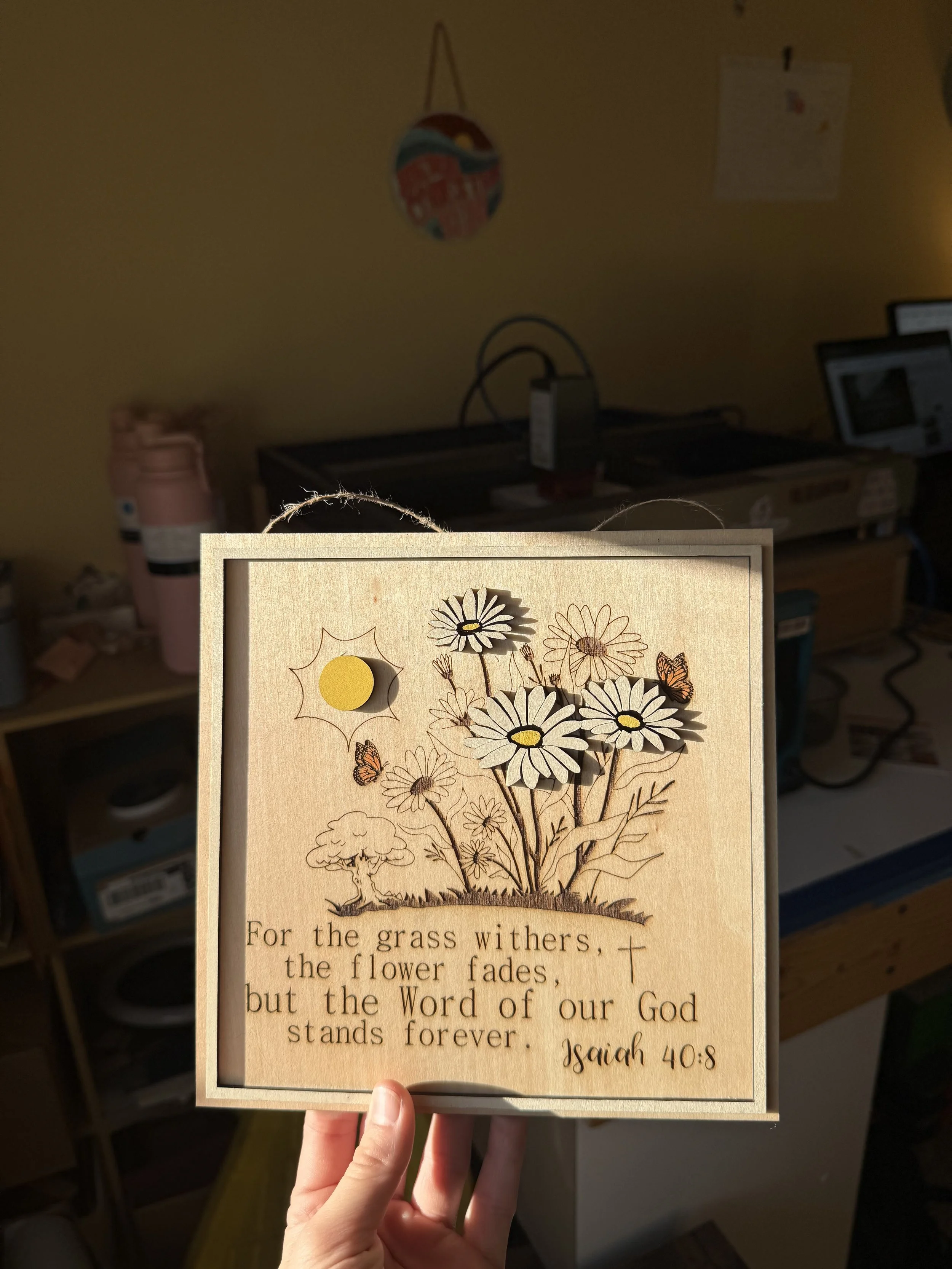 8x8 sign with hand-painted frame and cut-out daisies. Engraved Bible verse- Isaiah 40:8- and trees, butterflies, and more daisies.  Hangs nicely. 