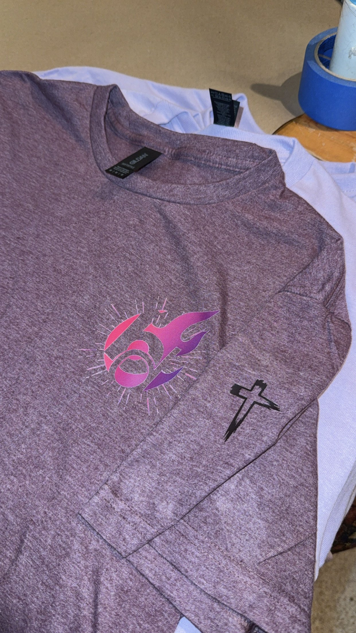 Purple T-shirt with custom left chest logo and a cross on the sleeve. 