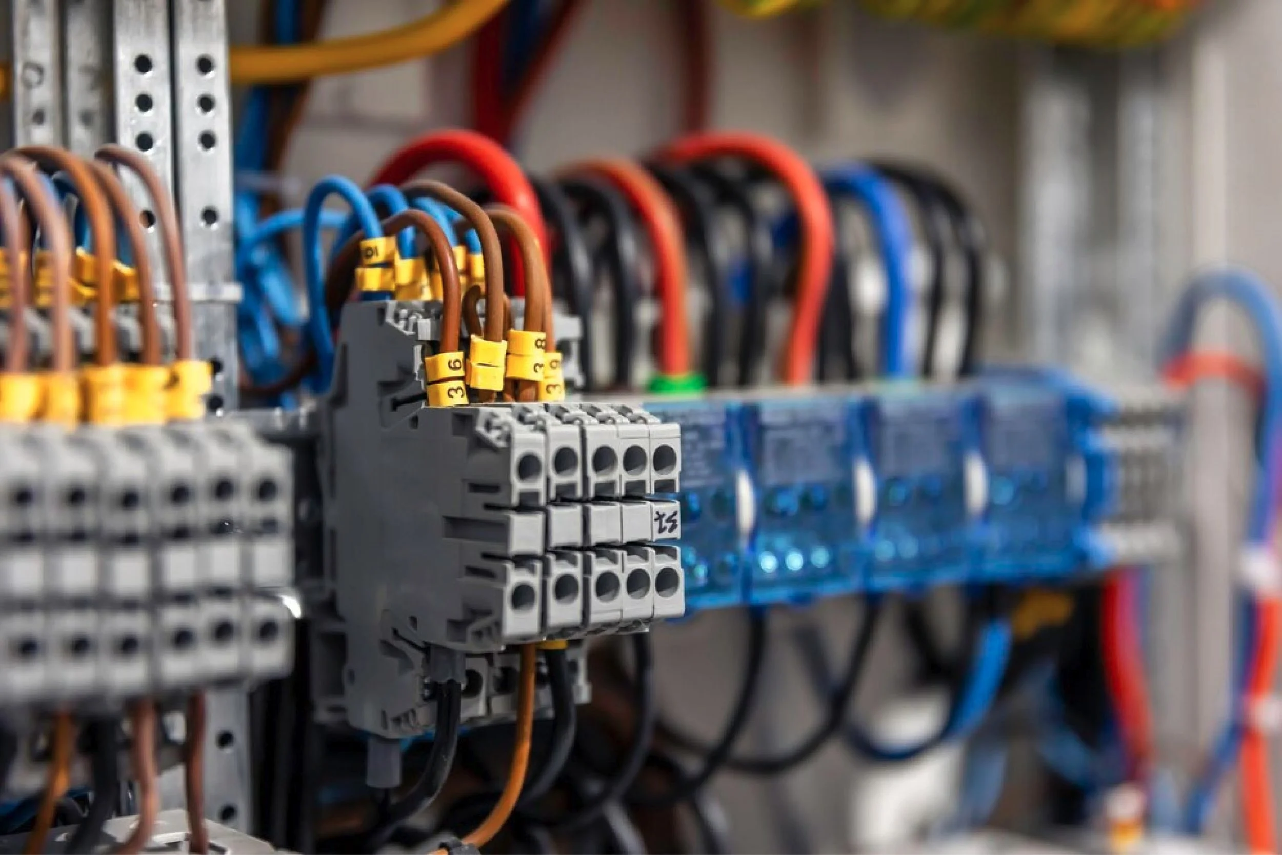 An electrical control panel with multiple wires, switches, and circuit breakers organized in rows.