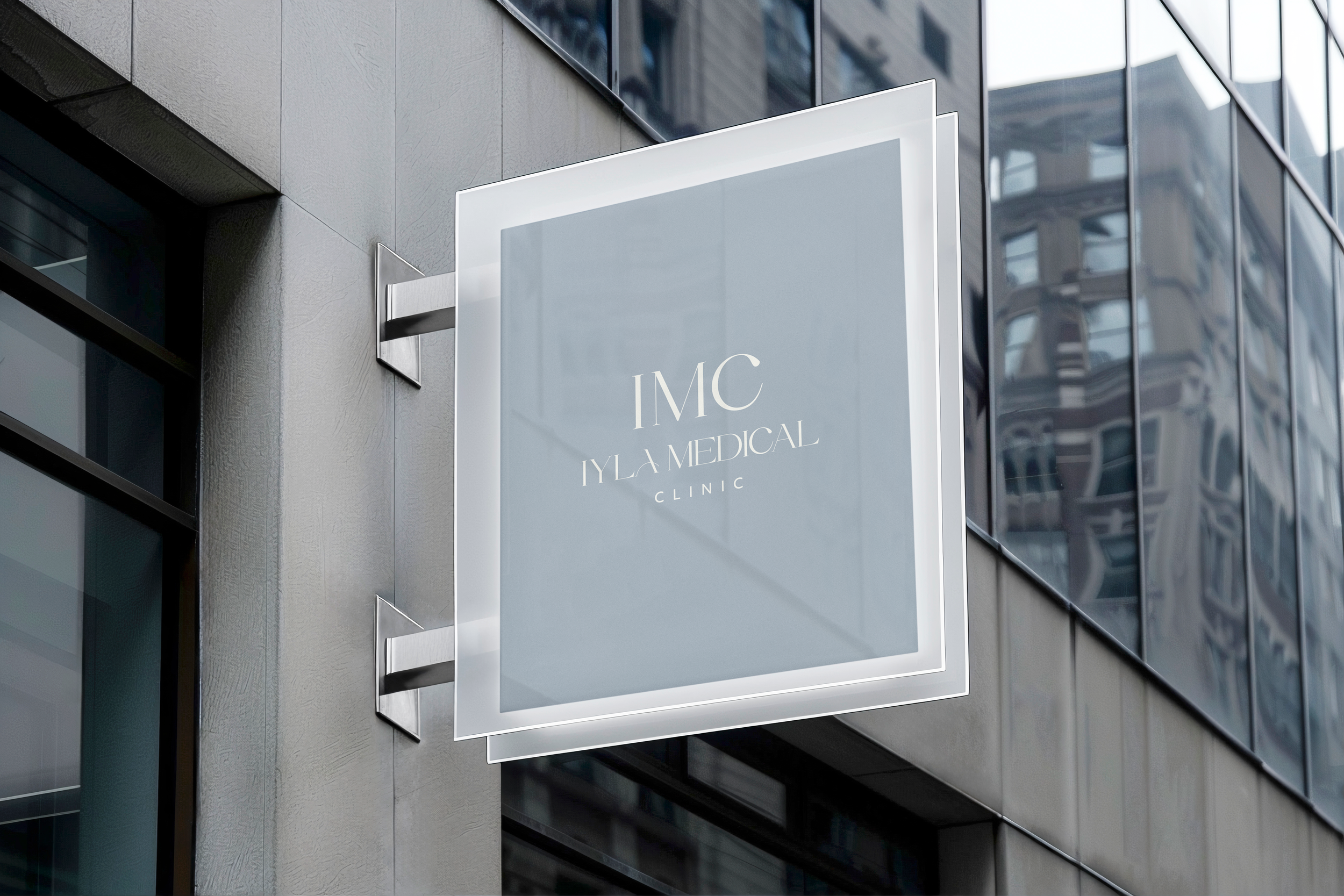 Sign for IMC Iyla Medical Clinic on the side of a modern building with glass windows.