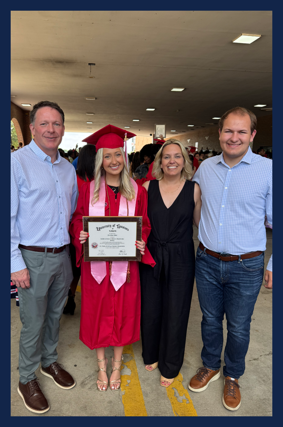 Bart Hebert for City Court Judge at University of Louisiana / U.L. graduation with family member in red cap and gown holding a diploma.