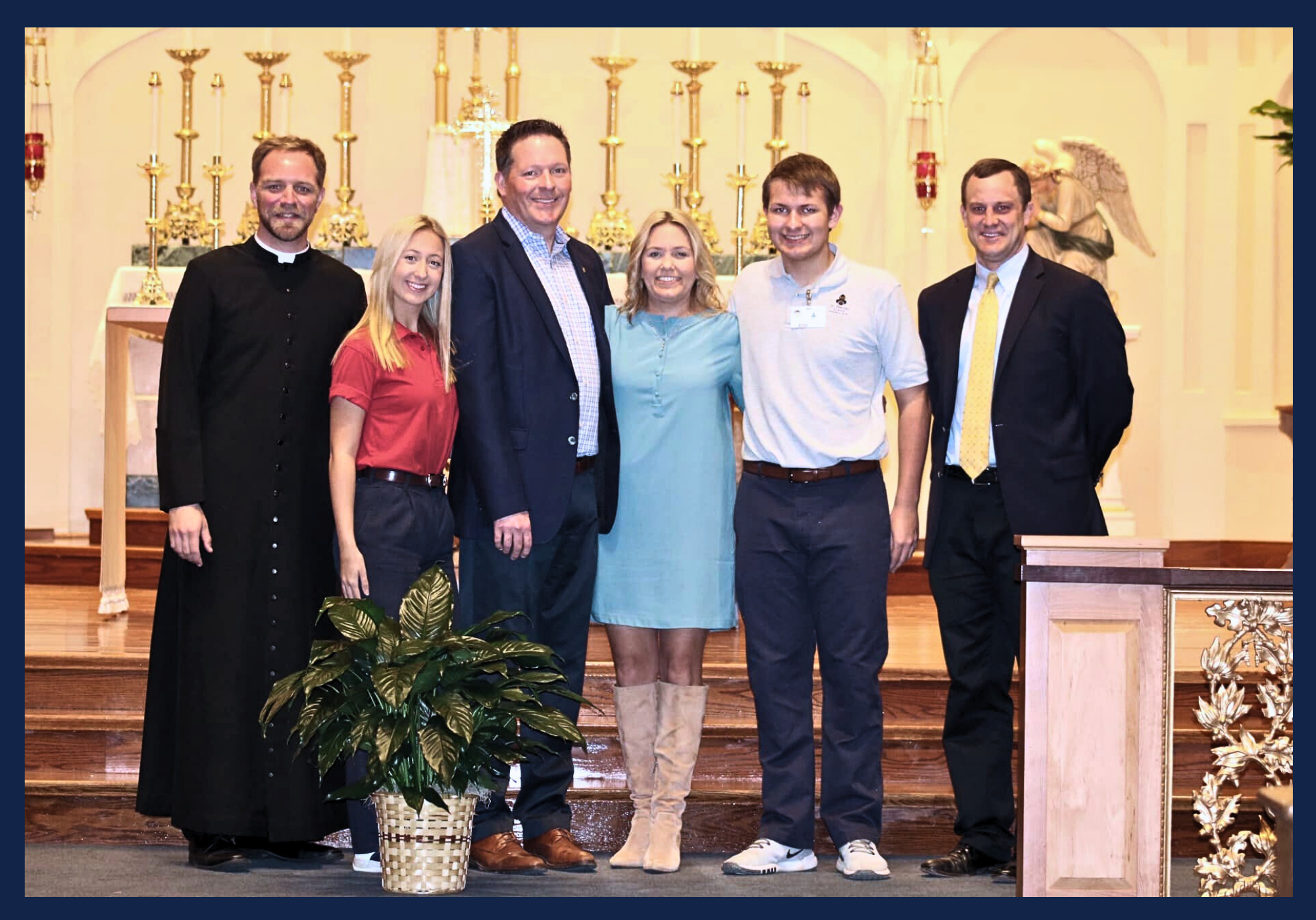 Bart Hebert for City Court Judge standing with his family and priest, Fr. Garrett McIntyre, in front of the St. Bernard Catholic Church altar.