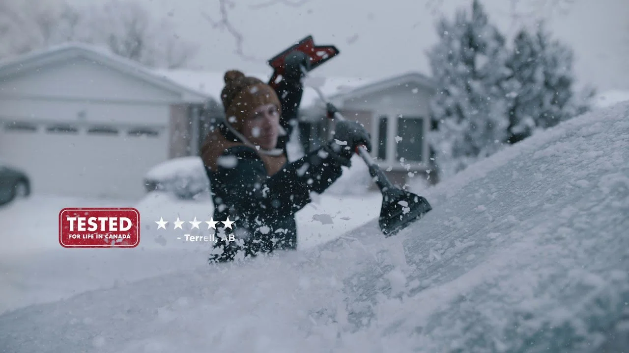 Man Scrapping snow and ice off the windshield - Canadian Tire