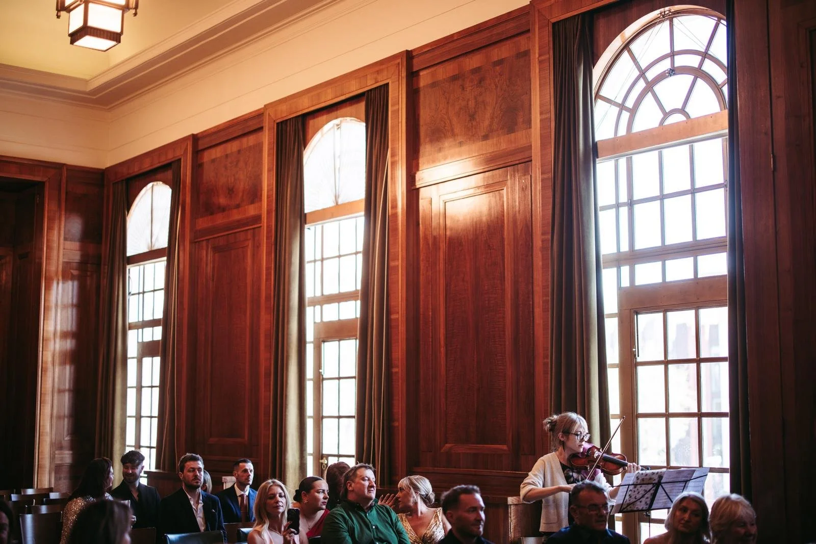 Front view of Talia Ramos, a woman performing on her violin at a wedding ceremony in Hackney Town Hall.