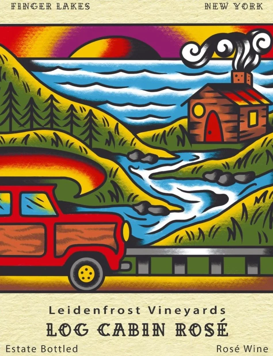 Colorful label design featuring a scenic landscape with mountains, a river, a house with smoke coming out of the chimney, a forest, a road, and a car in vibrant colors. Text on the label reads 'Finger Lakes, New York, Leidenfrost Vineyards, Log Cabin Rosé, Estate Bottled, Rosé Wine.'