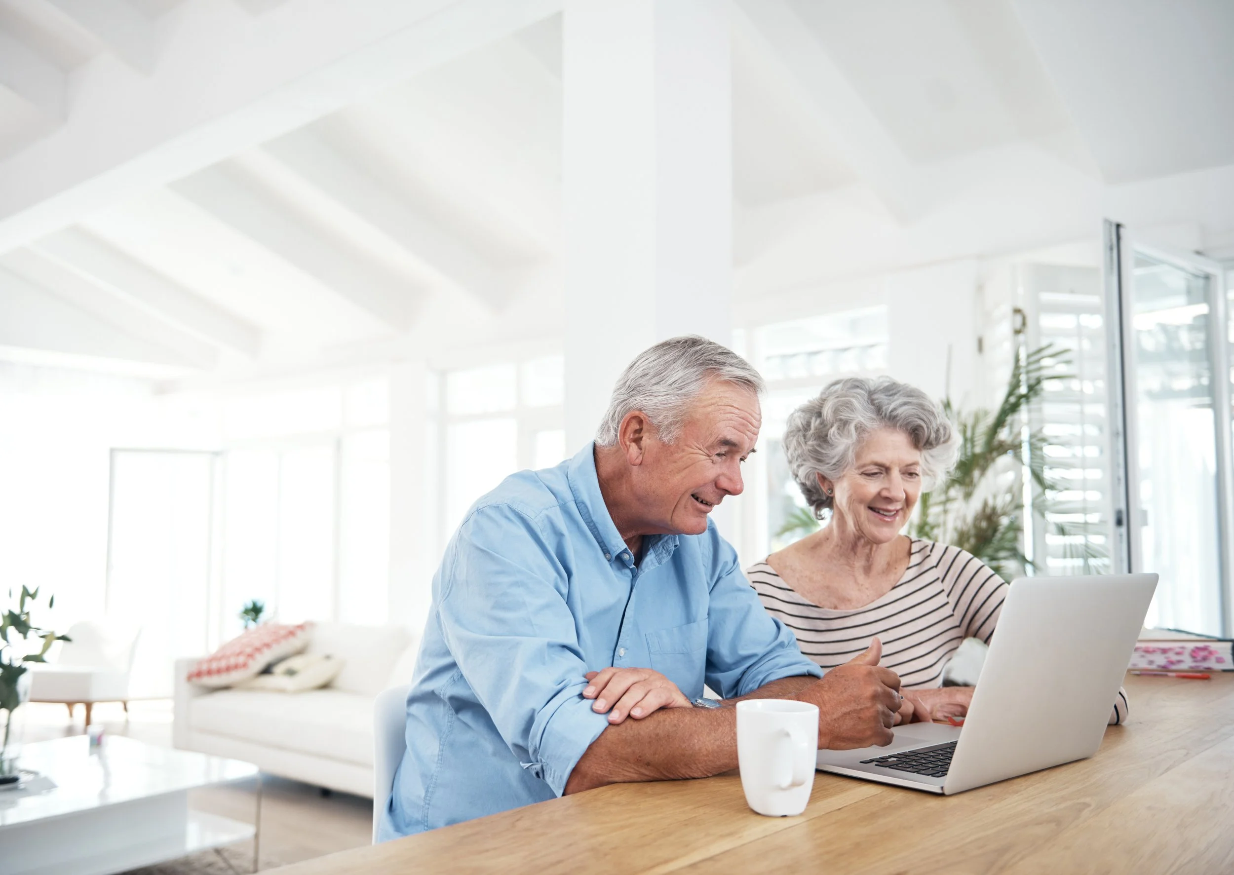 Man and woman sitting at counter top in home in front of a computer