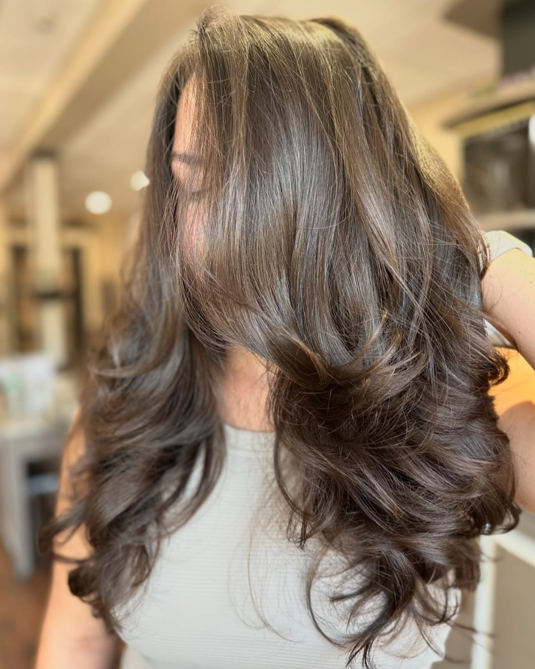 A woman with long, wavy, brown hair cascading over her shoulder.