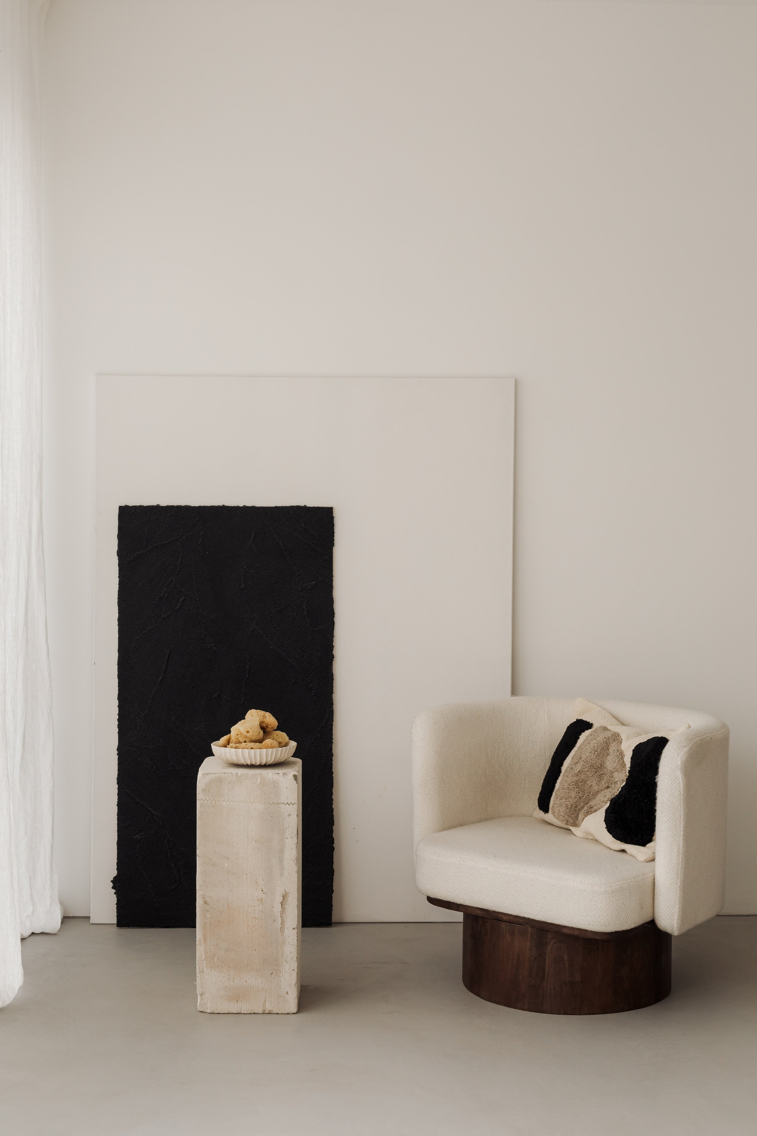 kaboompics_a-cozy-cream-colored-armchair-placed-next-to-minimalist-black-and-white-artwork-with-a-small-side-table-adorned-with-natural-objects-36989.jpg