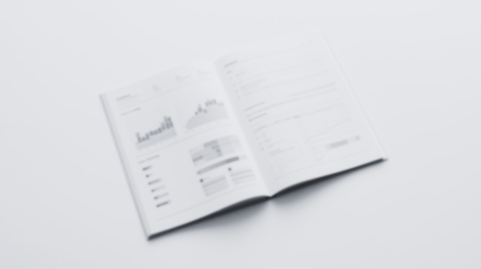 Open magazine with graphs and charts on a white surface