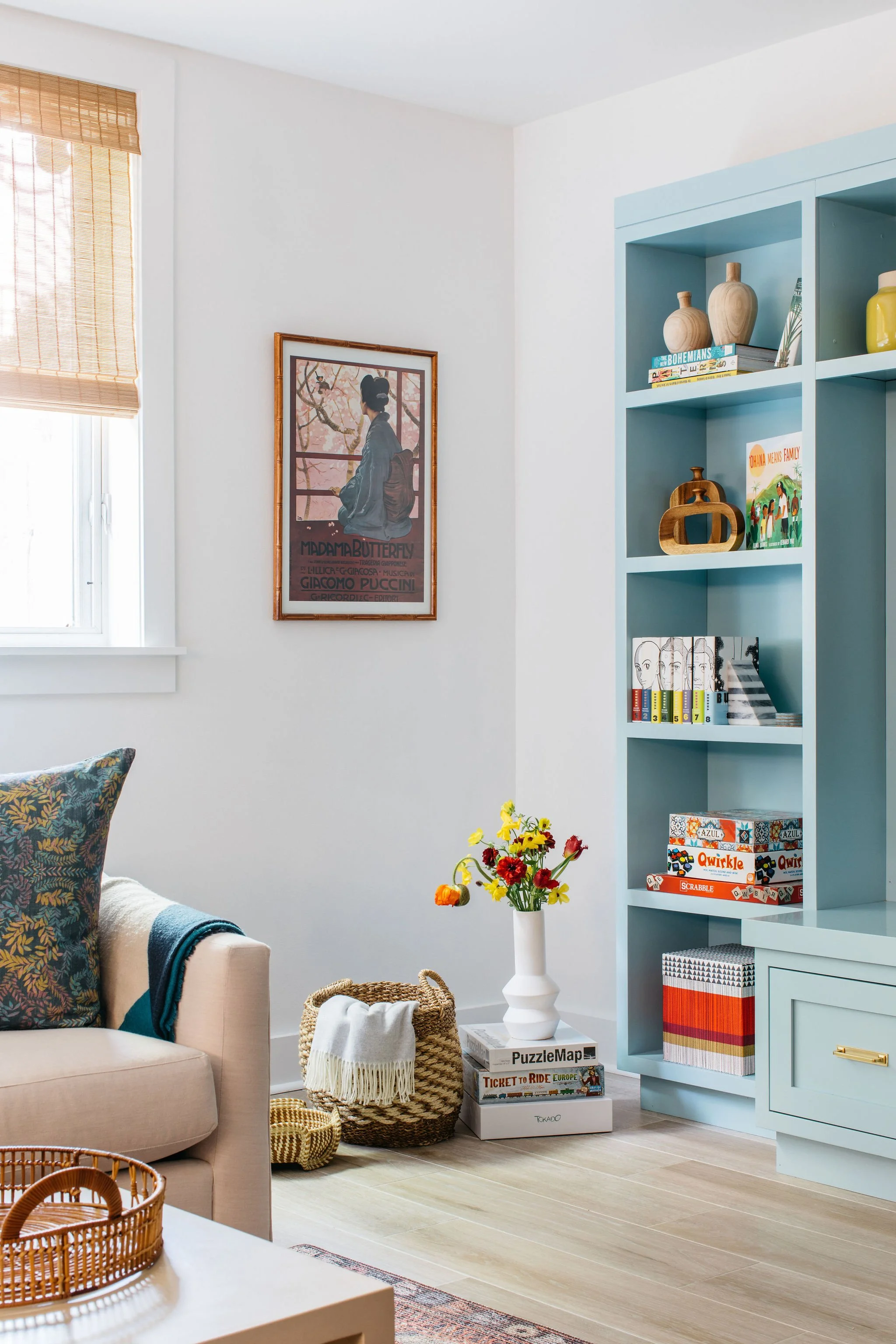 Corner of living space with natural light, built in book shelves and classy aesthetic.