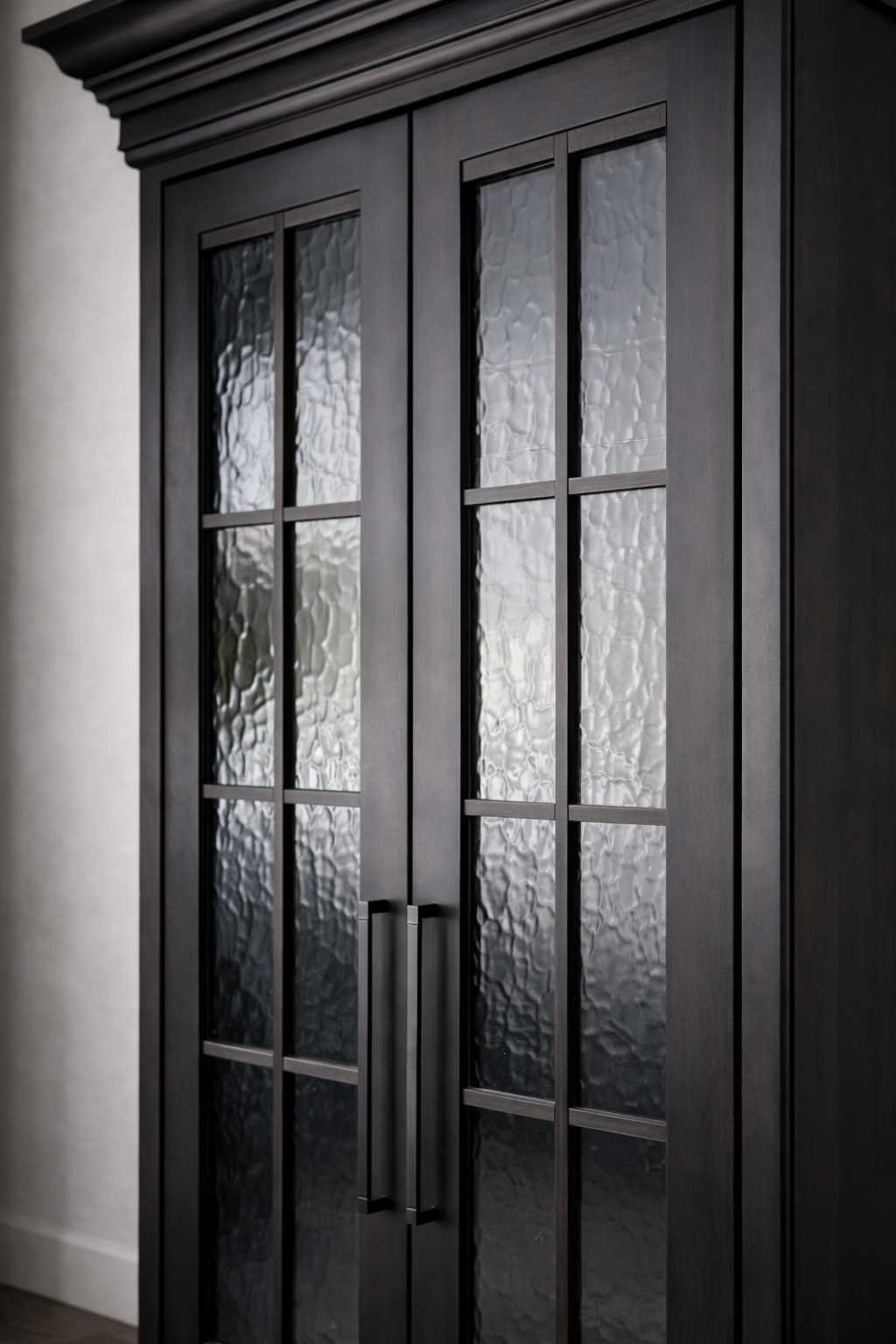 Black wooden cabinet with textured glass paneled doors and black handles