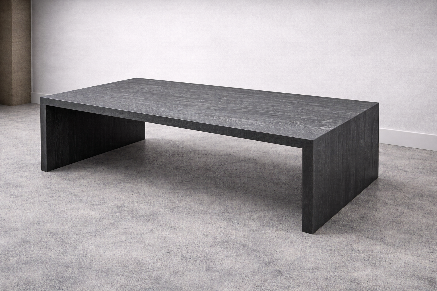 A modern, black wooden bench with a minimalist design in an empty room with light gray walls and carpeted floor.