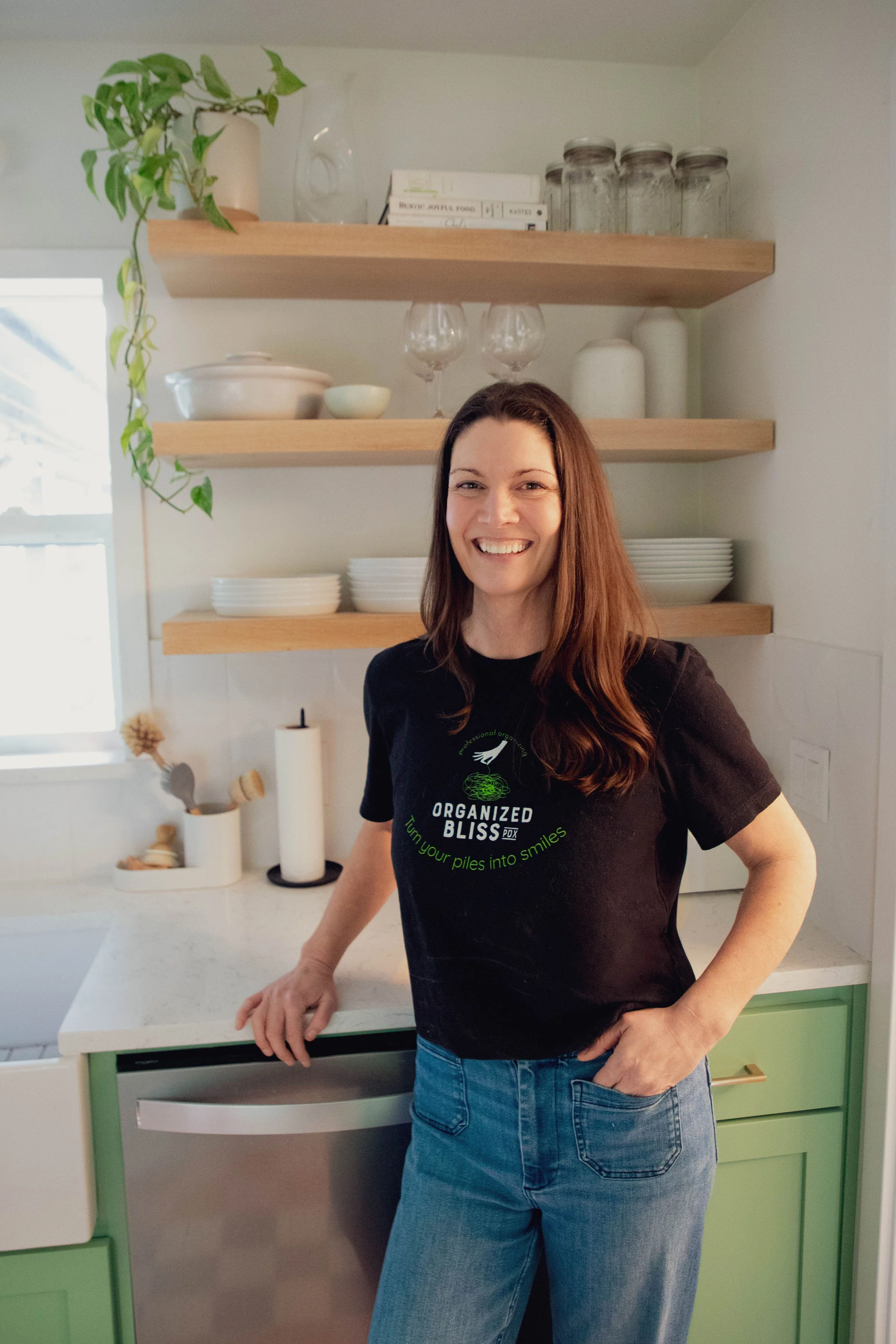 Person holding a whleafy plant, against a plain white background.