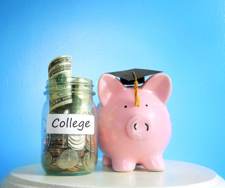 A pink piggy bank wearing a black graduation cap with a gold tassel, and a glass jar filled with dollar bills and coins labeled "College," both placed on a white surface against a blue background.