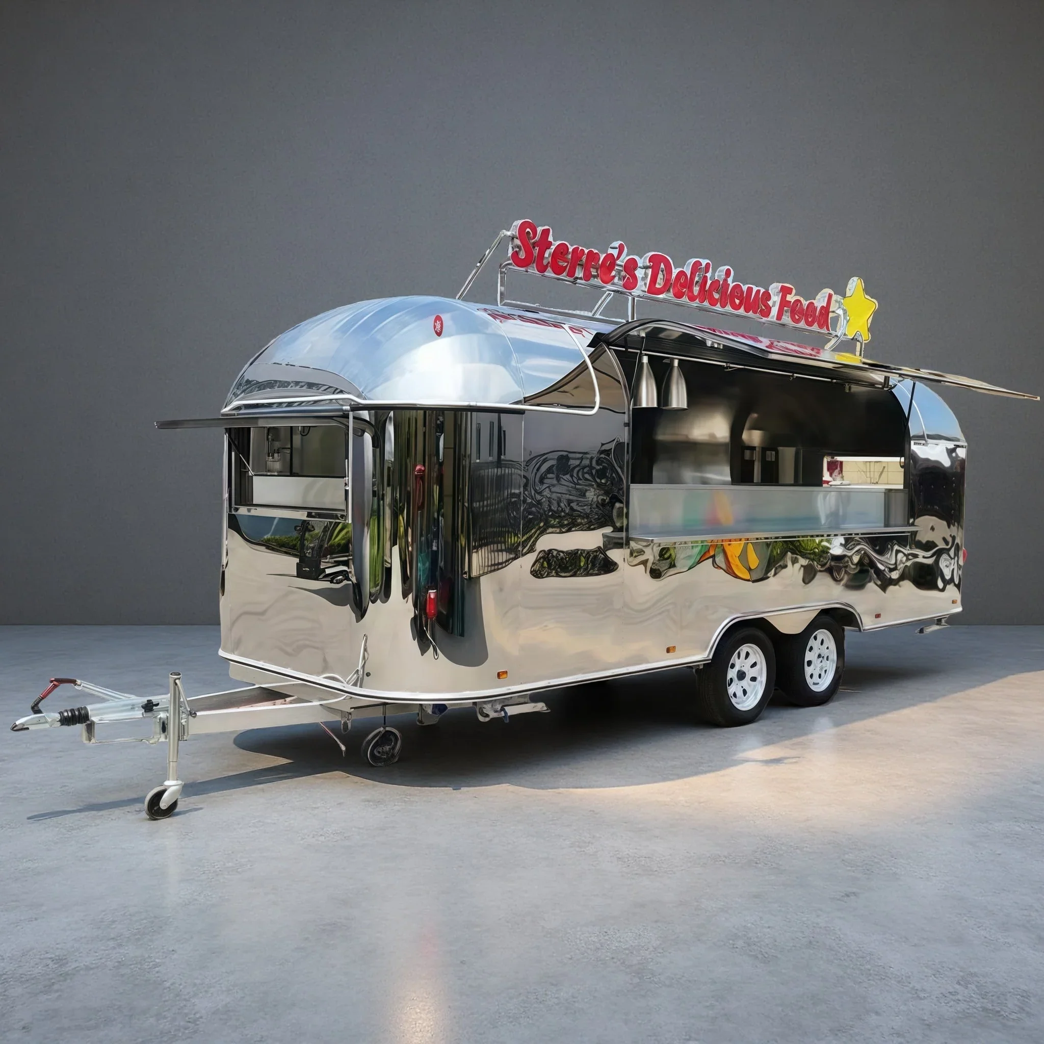 A shiny, metallic food trailer with a sign that reads 'Sterre's Delicious Food' and a yellow star on top.