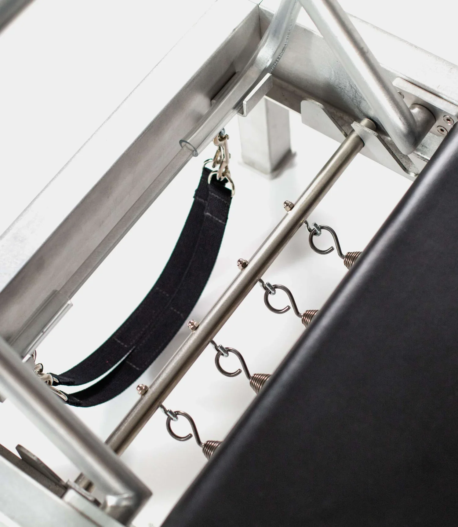 Close-up view of the springs and footbar of a classical Pilates reformer