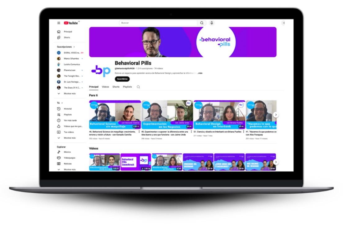 Pantalla de una computadora portátil que muestra un canal de YouTube llamado 'Behavioral Pills' con varios videos relacionados con ciencias del comportamiento y diseño conductual, en fondos morados y azules.