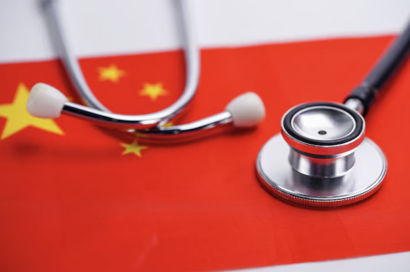 Stethoscope placed on the Chinese flag with a red background and yellow stars.