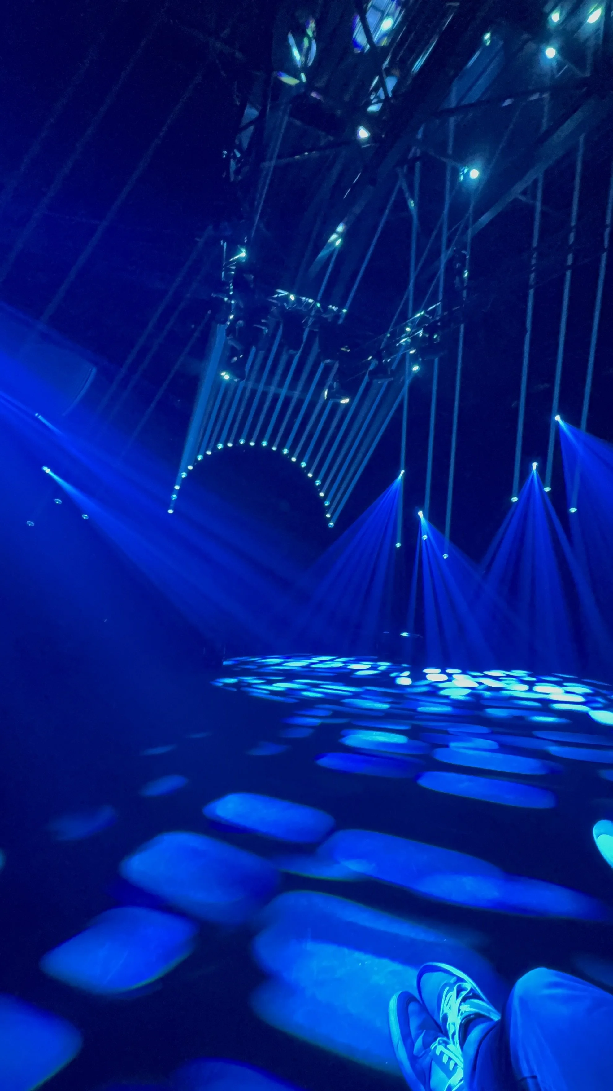 Dramatic cinematic stage lighting by EchoLight using sharp white spotlights and vibrant red beams to shape emotions and craft a powerful presence  for high-end stage productions