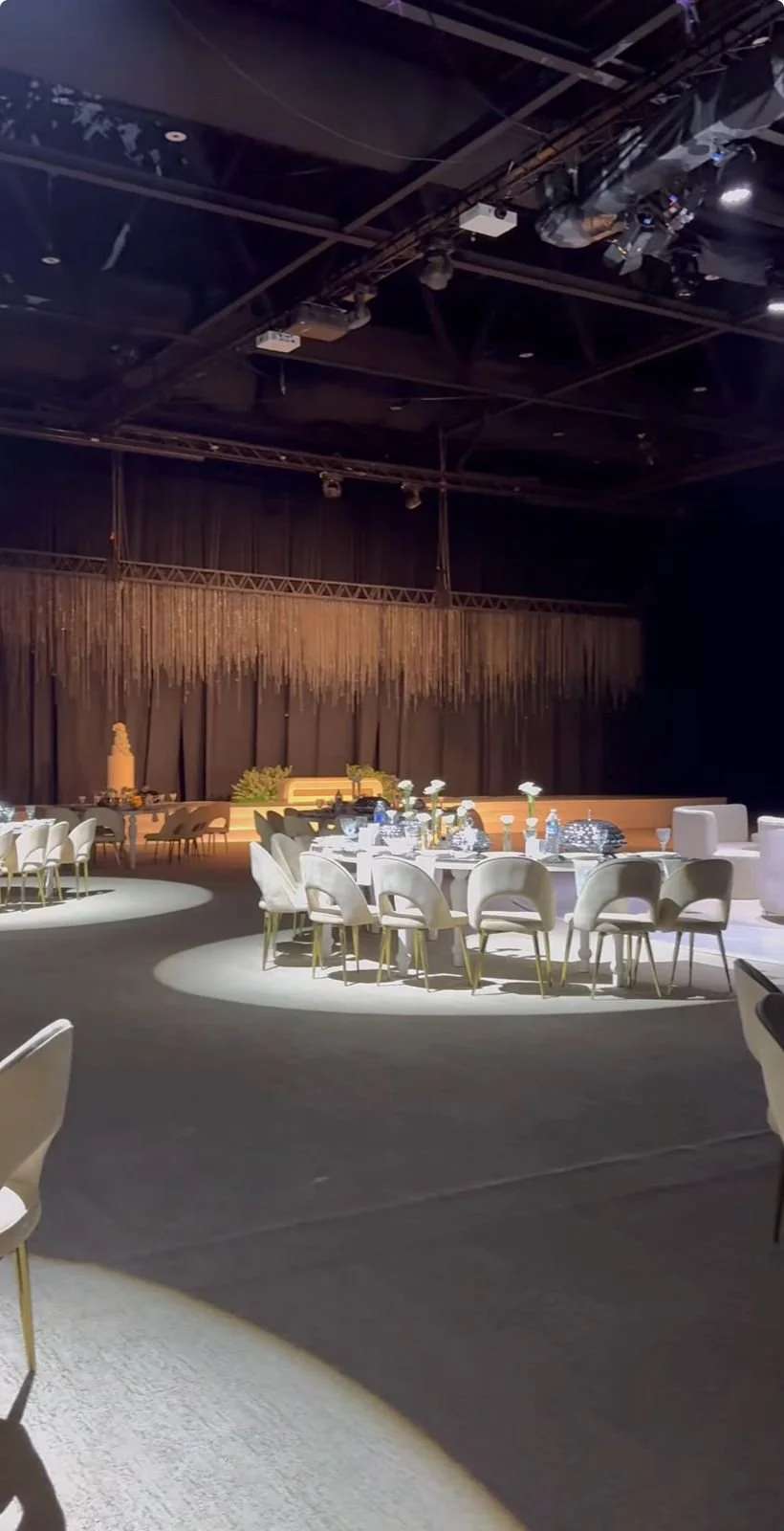 Luxury wedding stage lighting and professional event production by EchoLight , featuring precision spotlighting on banquet tables and a golden cinematic stage backdrop to create an immersive atmosphere.