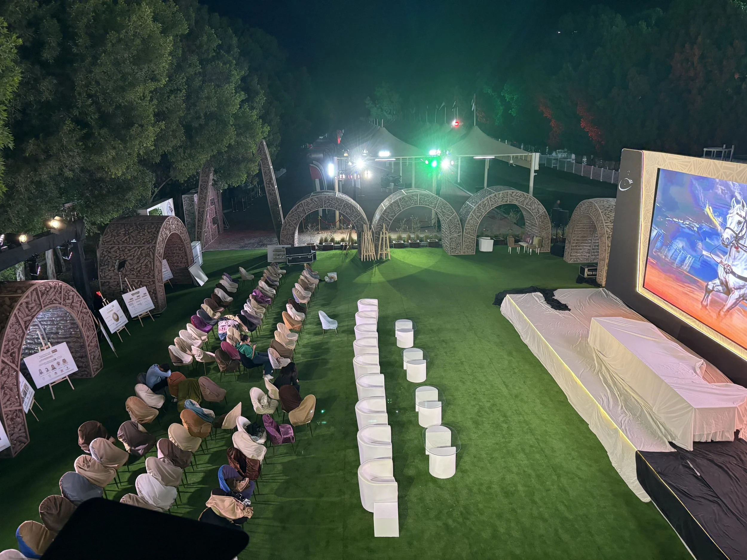 Professional outdoor corporate event lighting for the Emirates International Endurance Village (EIEV) by EchoLight, featuring green wash lighting and LED screen integration