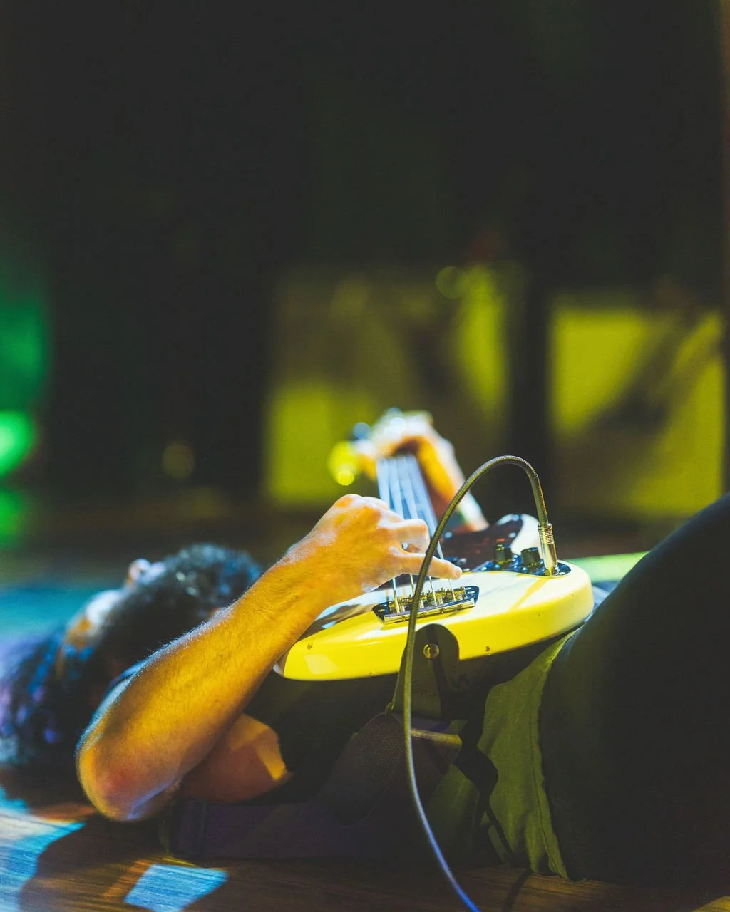 Bass player of Ovlov lying down on stage while playing his instrument.