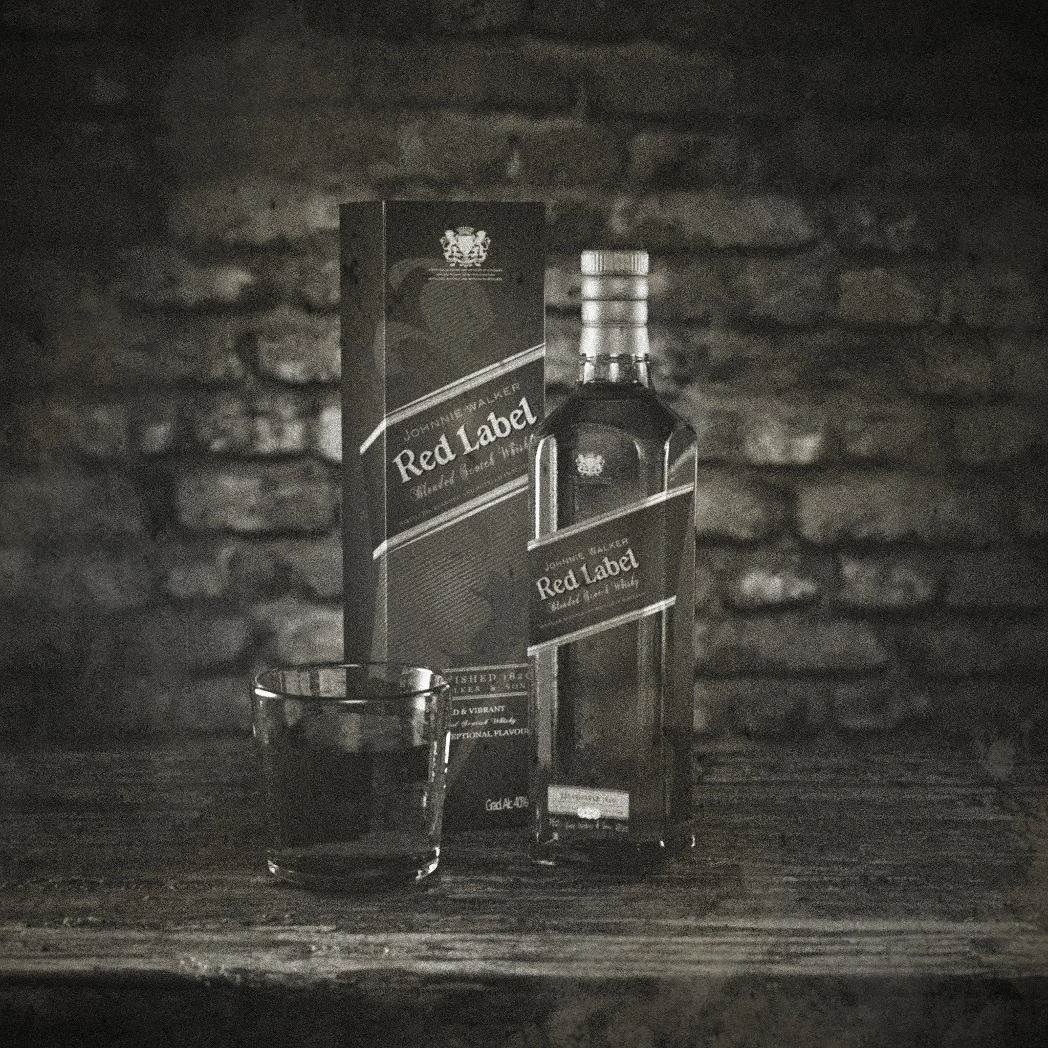 A bottle of Johnnie Walker Red Label whiskey, its box, and a glass filled with dark liquid on a wooden surface with a brick wall background.