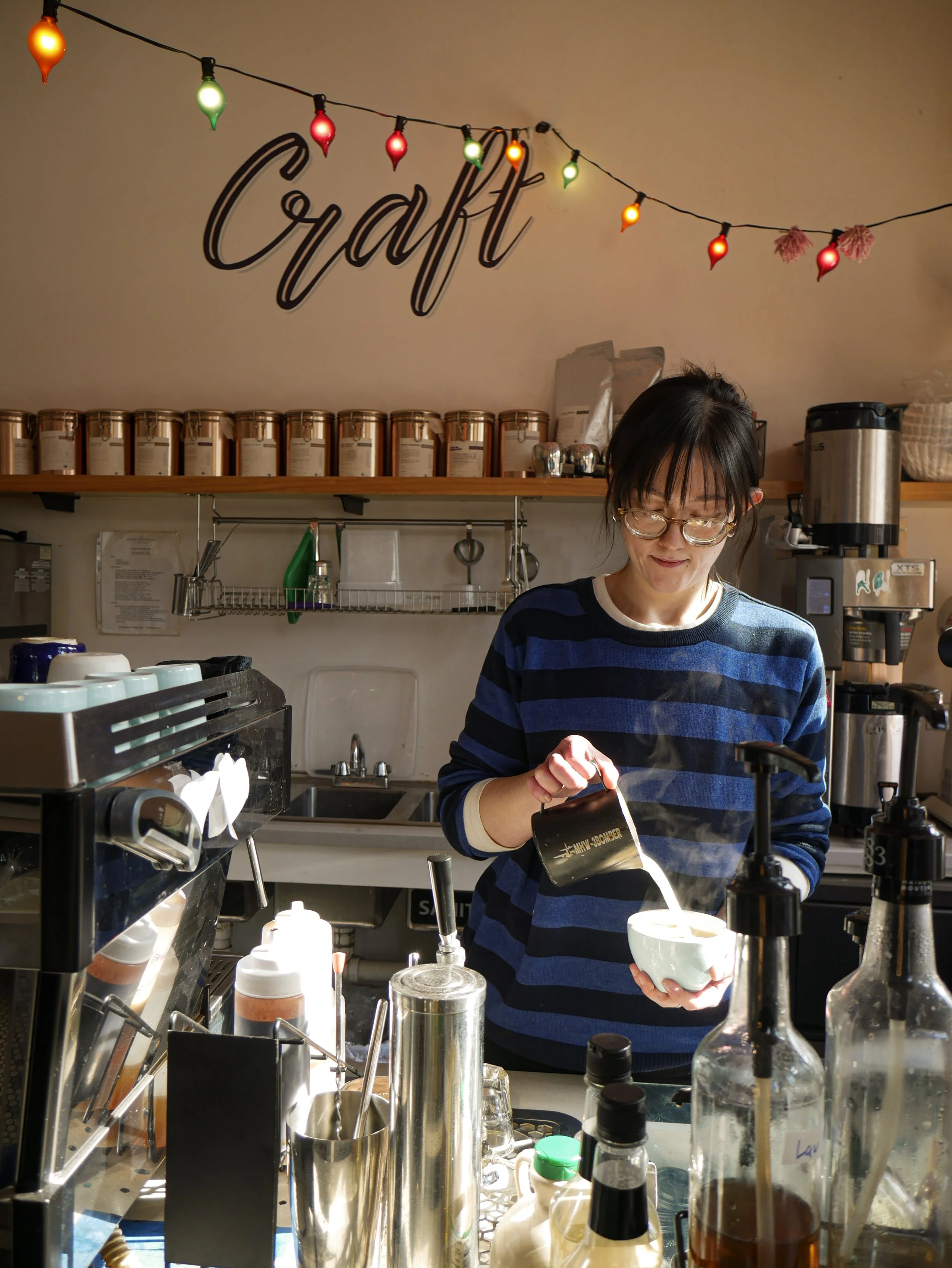Sarah in Logan Square cafe pouring steamed milk