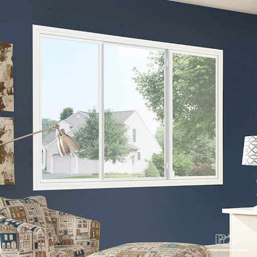 Interior view of a bedroom with a large window showing a suburban neighborhood with houses and trees outside.