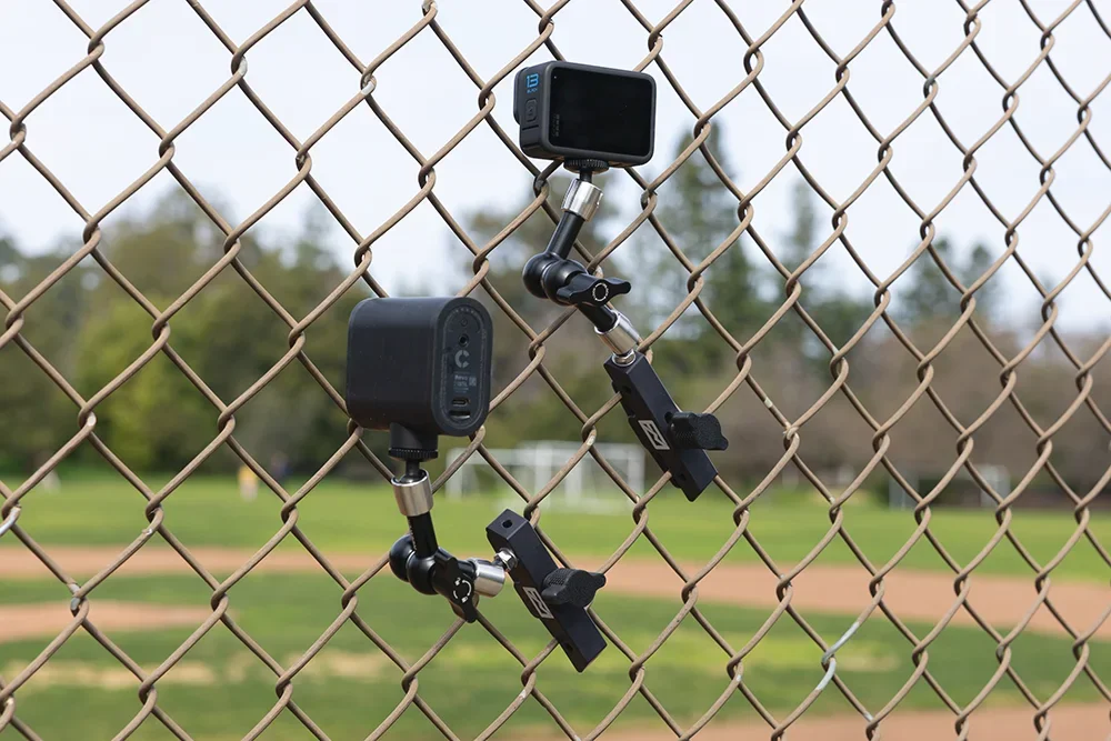 A Mevo camera and GoPro Hero Black 13 mounted using the Fence Mod Chain Link Fence Camera Mount.