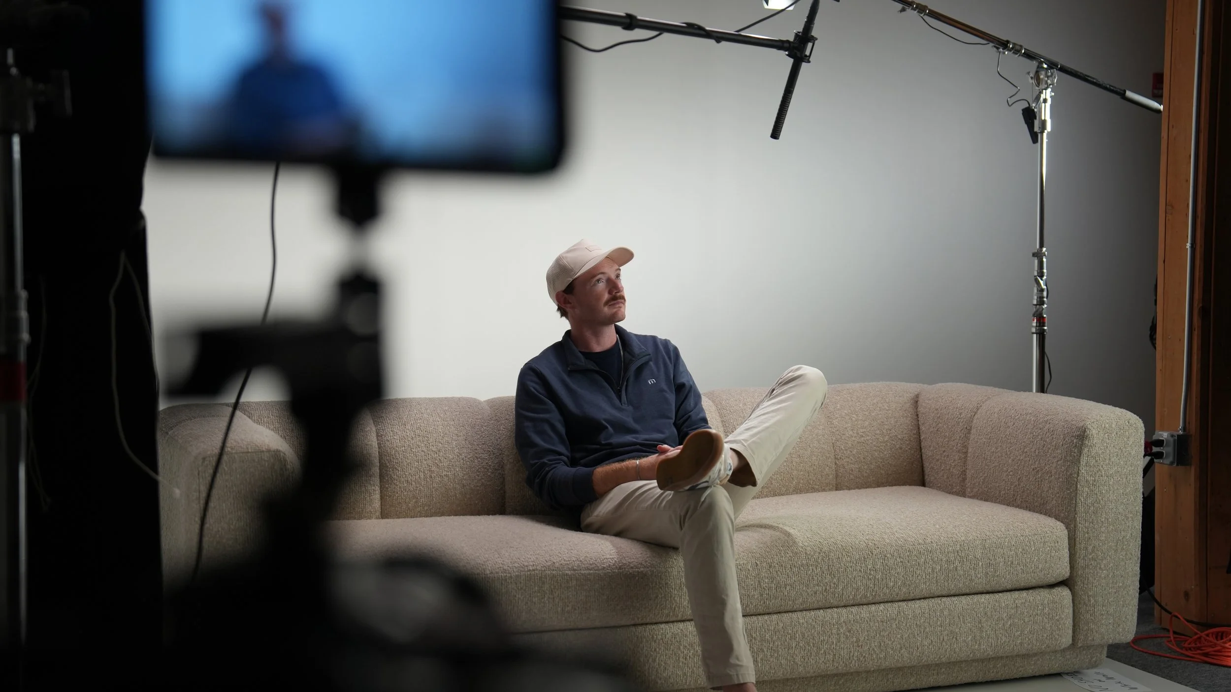 Producer and director, Mark, sits on set during a commercial video production day.