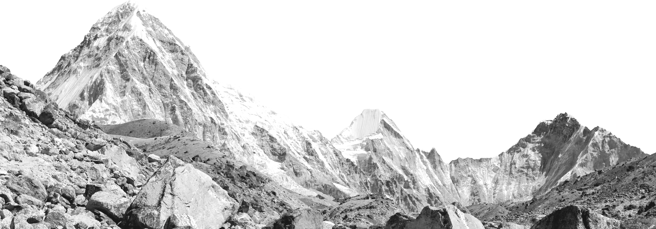 Black and white photo of snow-capped mountain peaks with rocky foreground.