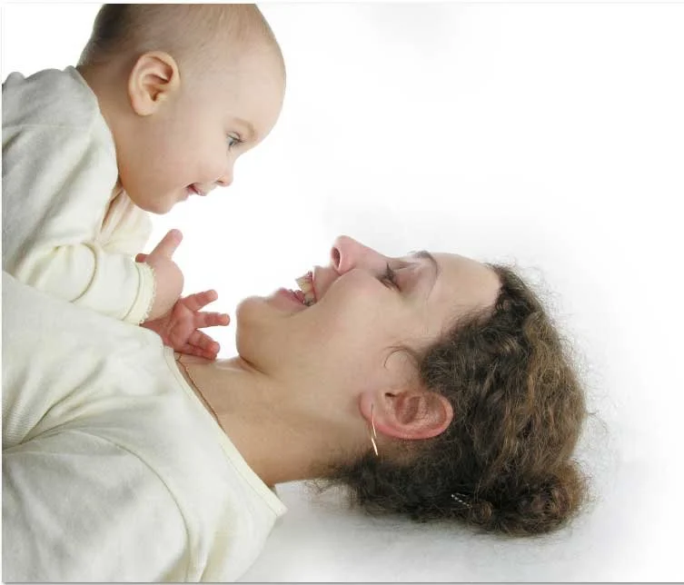 Mother smiling at her baby during a calm bonding moment in early postpartum.