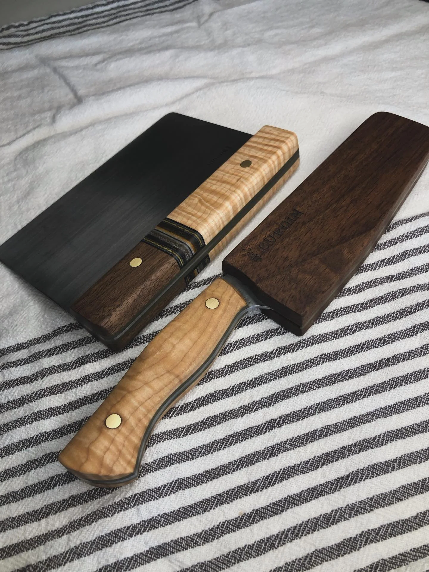 Scraper and petty matching set. Curley maple, and walnut and a gcarta spacer on the scraper. Also my fist wooden saya with an embedded magnet to hold the knife in. Fun one! 

More knives in the works slowly yet steady when time allows me to get in th